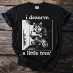 Black t-shirt with a wolf in torn jeans in front of a refrigerator holding cake.