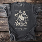 Dark t-shirt with wildflower illustration labeled "The Meadow Cabinet: Wildflower Plate XXXVIII".