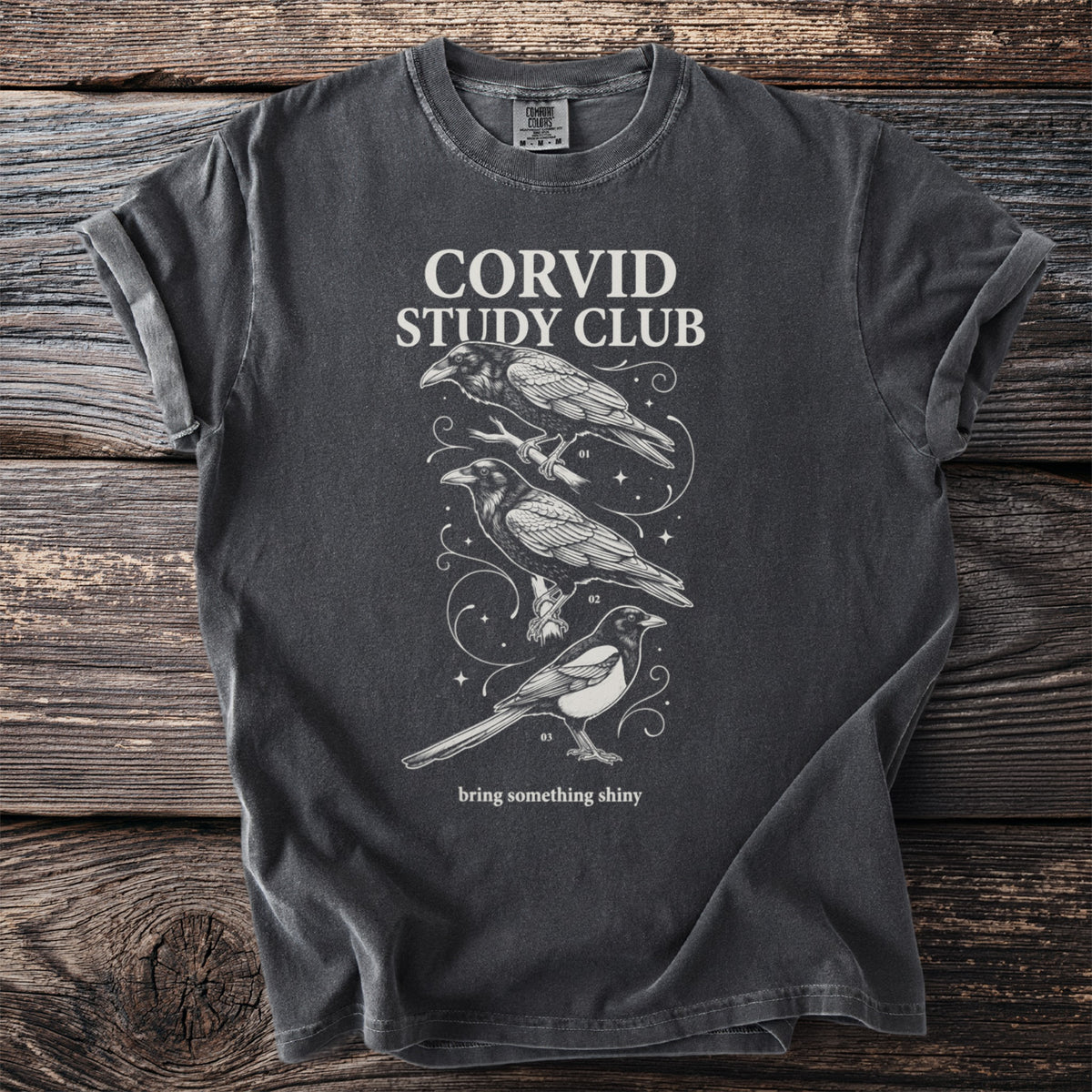 Dark grey t-shirt with "CORVID STUDY CLUB" text and illustrations of birds.