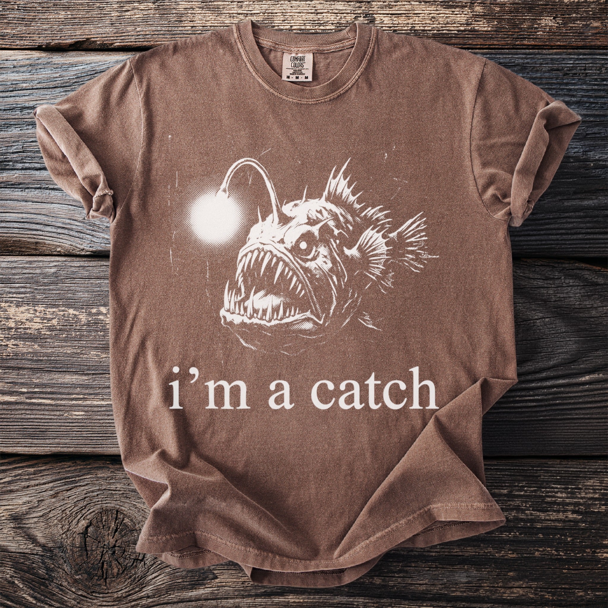 Brown t-shirt with anglerfish graphic and text "i'm a catch".