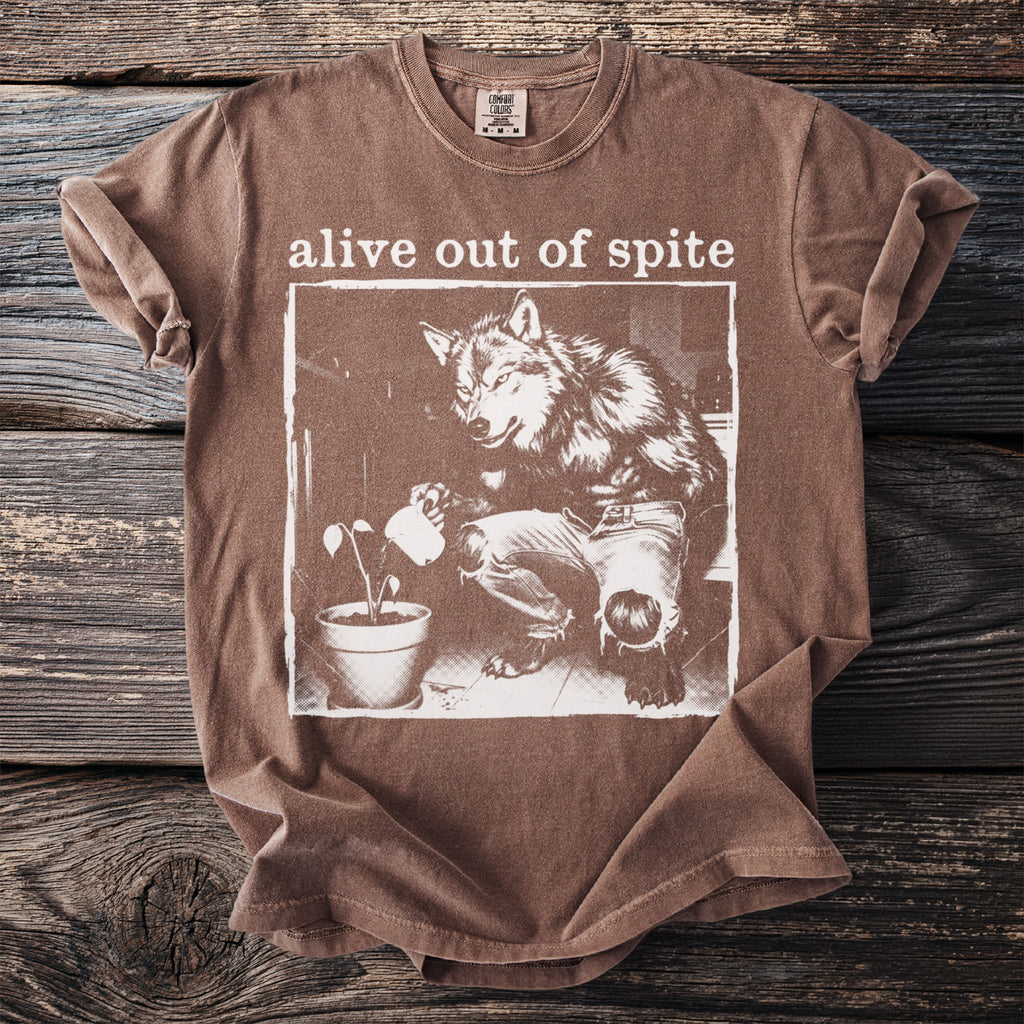 Brown t-shirt with "alive out of spite" and werewolf watering a plant.