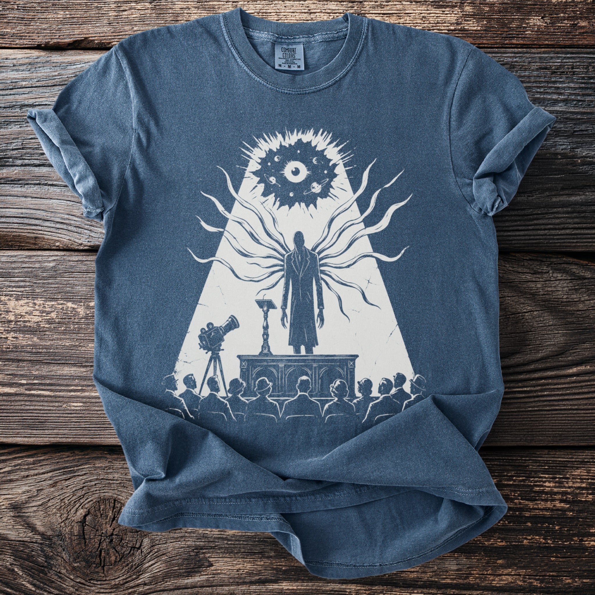 T-shirt with graphic of a tall figure with tendrils speaking to an audience.