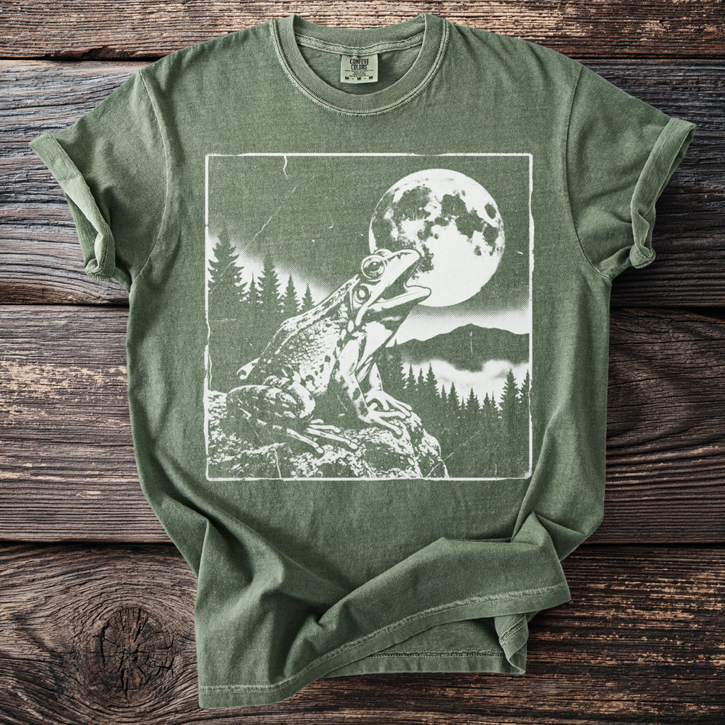 Green t-shirt with a white graphic of a frog on a rock under the moon.