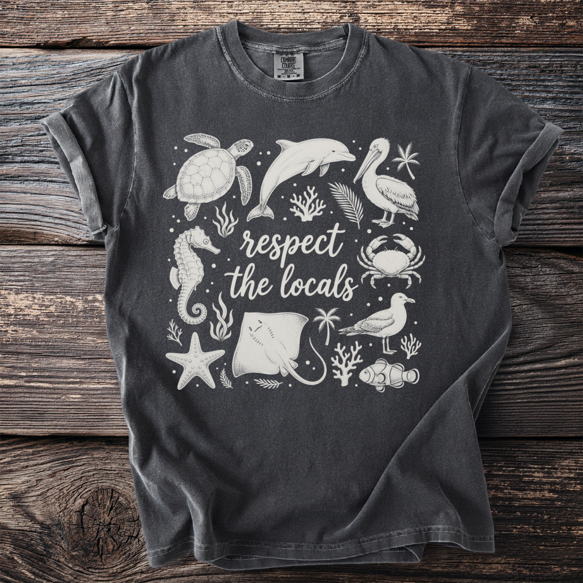 Dark t-shirt with white line art of sea creatures and text "respect the locals".
