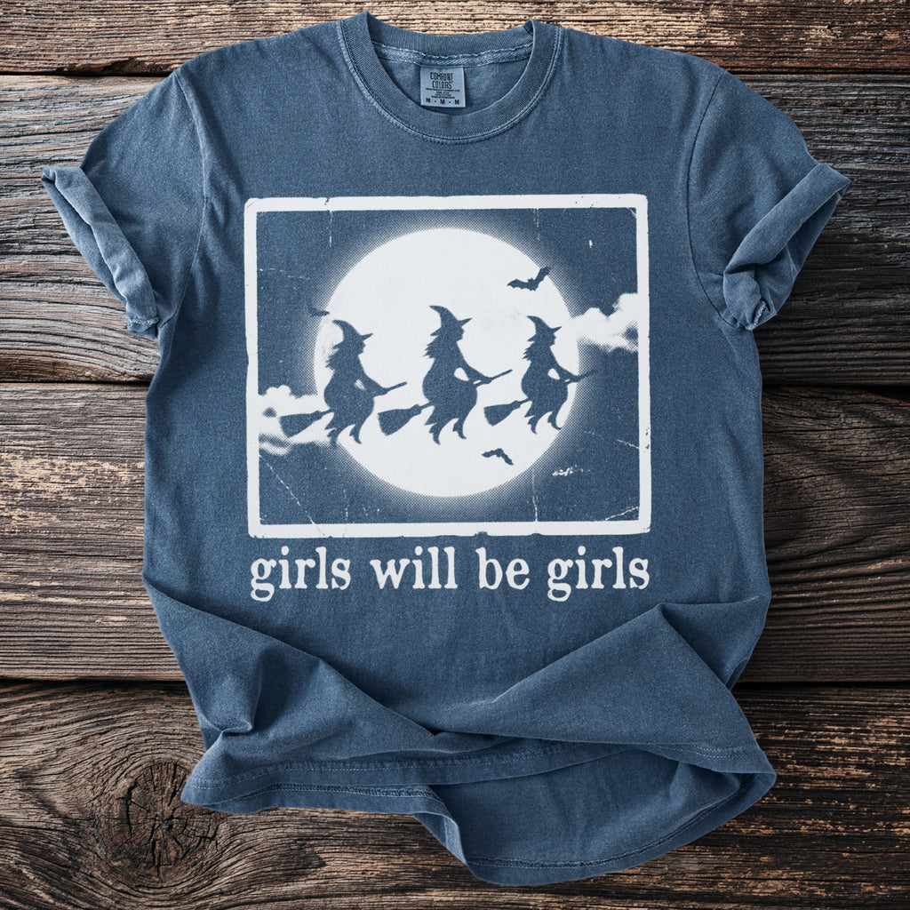 T-shirt with three witches flying on broomsticks in front of a full moon.