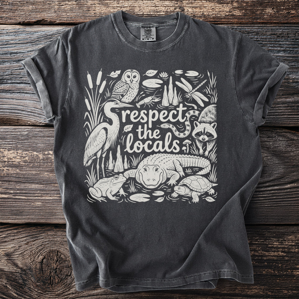 Dark gray t-shirt with white "respect the locals" text and swamp wildlife illustration.