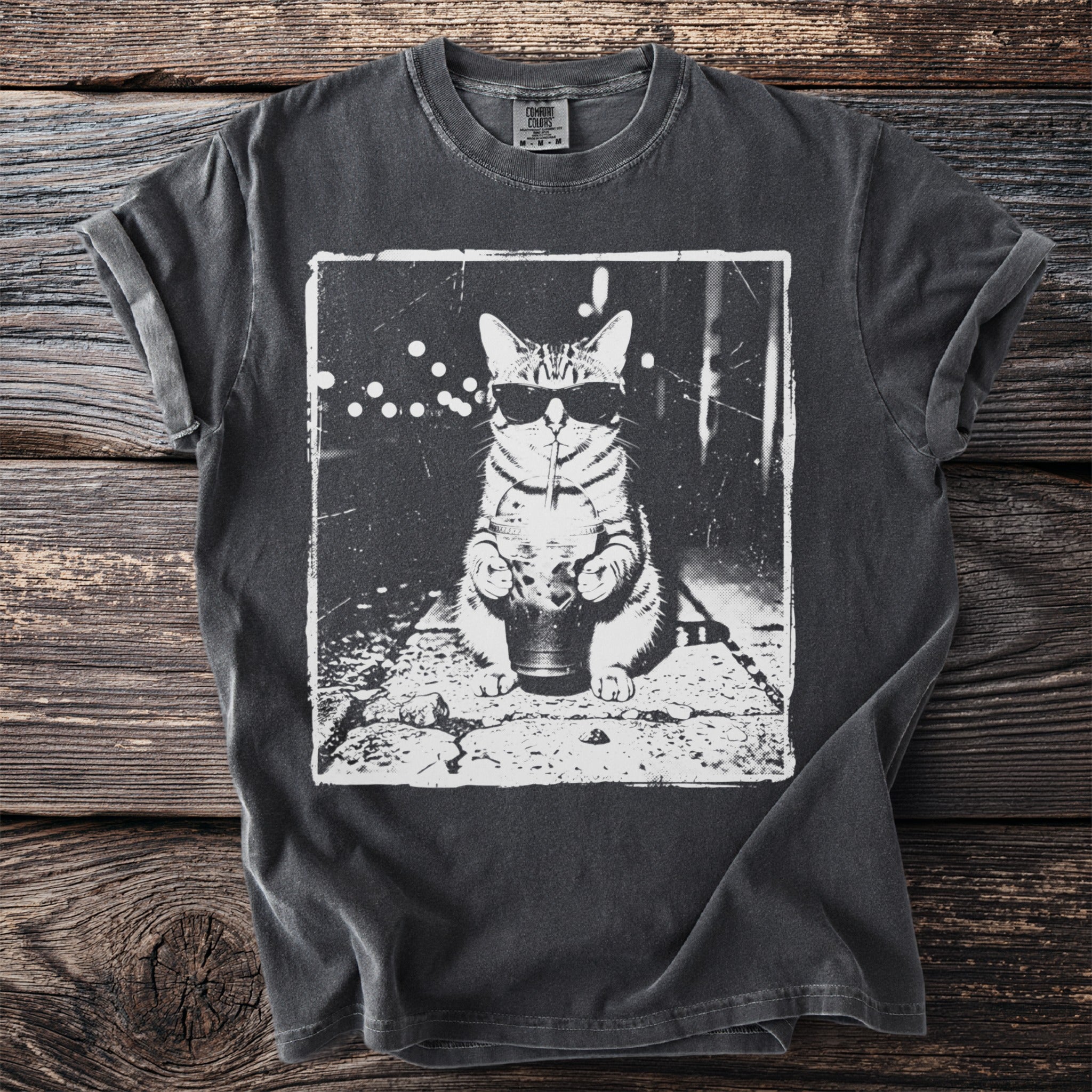T-shirt with a black and white graphic of a cat wearing sunglasses and drinking from a cup.