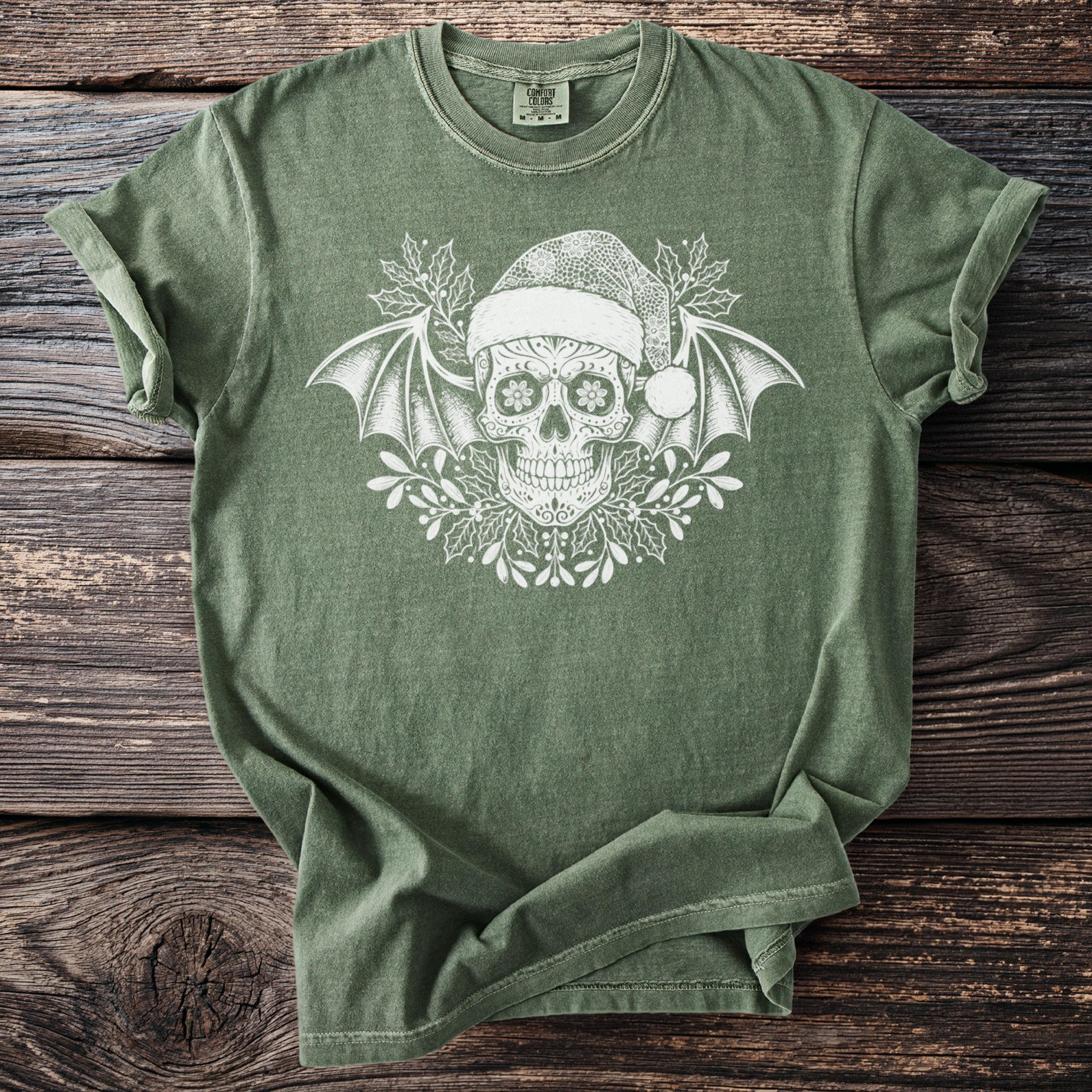 Green t-shirt with a white sugar skull wearing a Santa hat and bat wings.