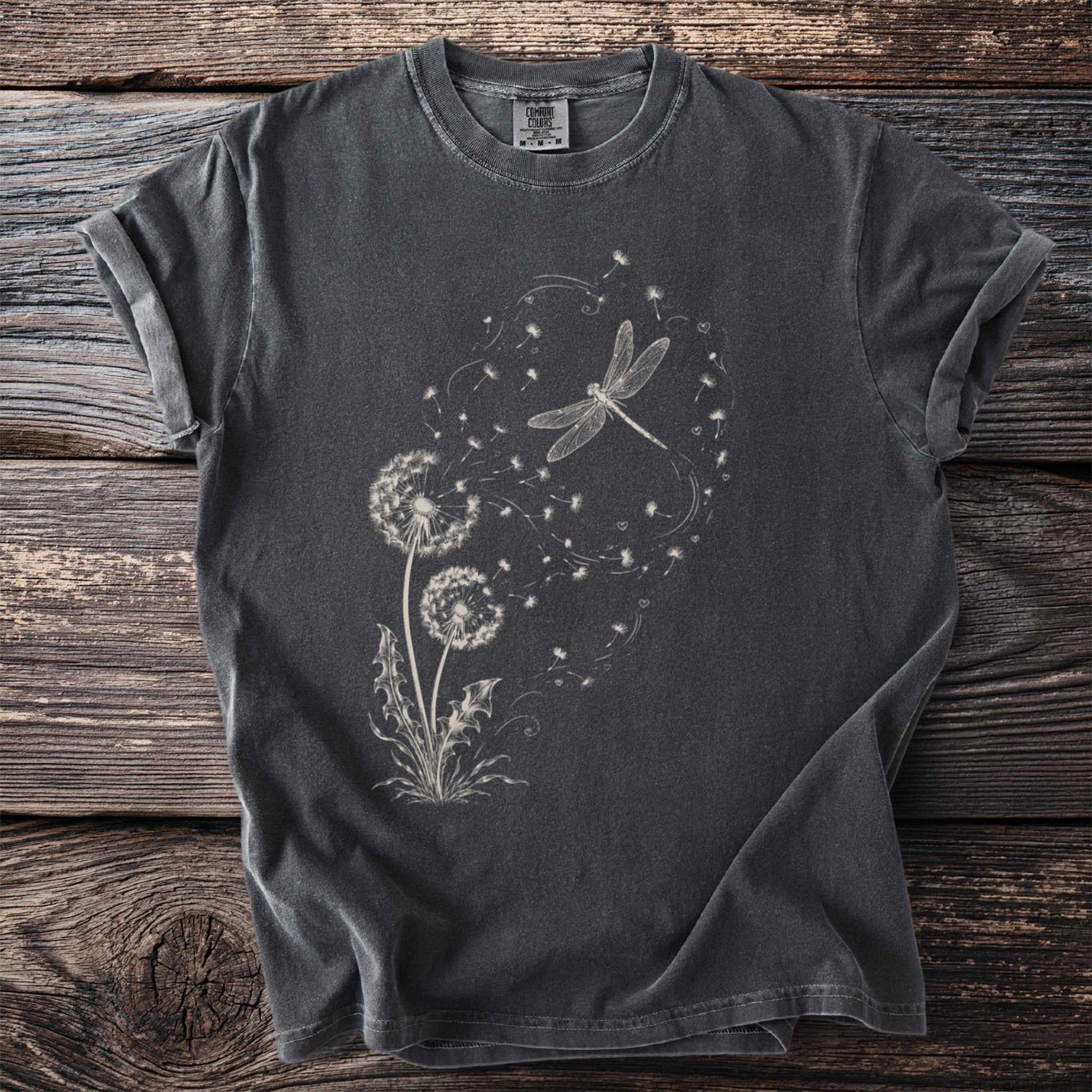 Dark t-shirt with white dragonfly and dandelion seed graphic.