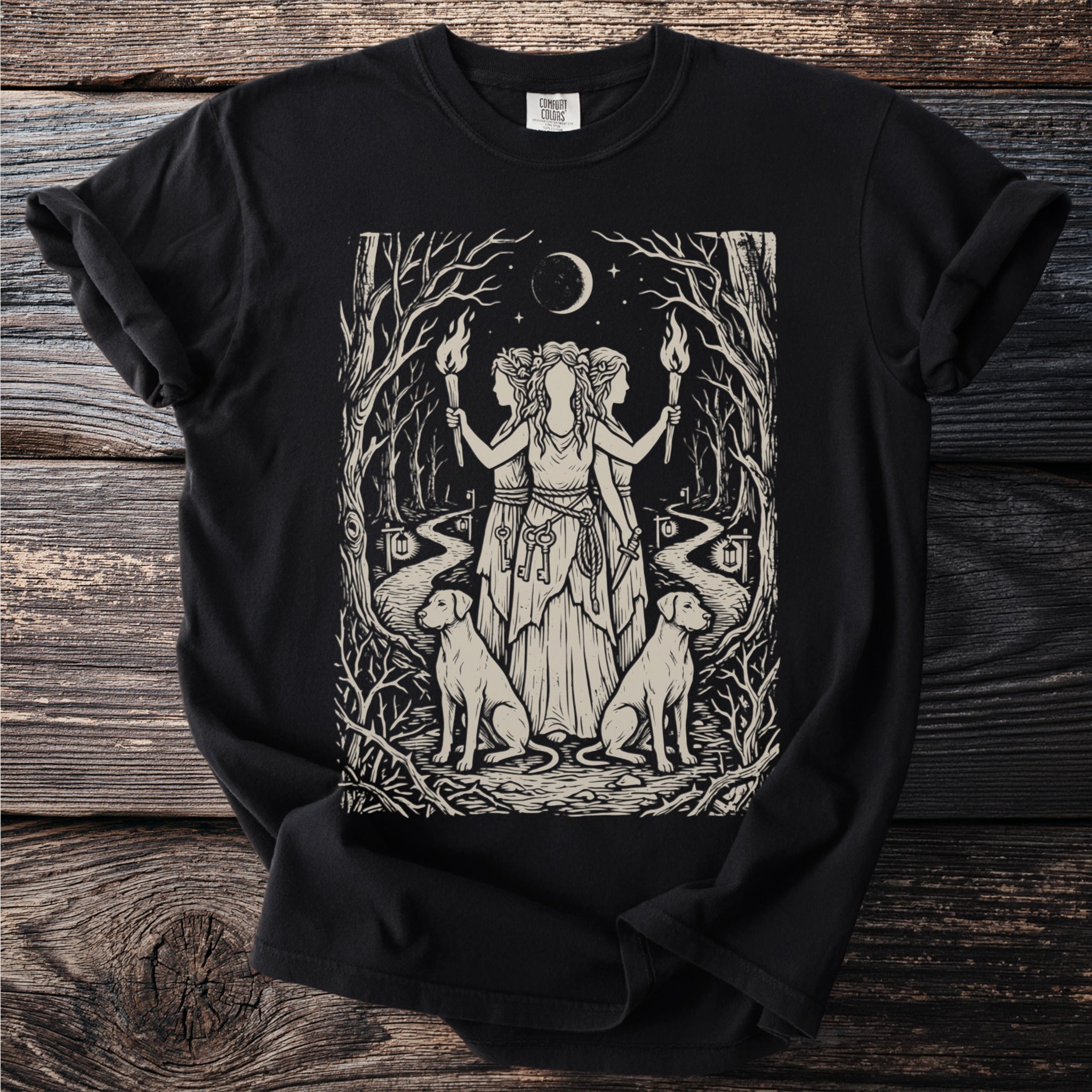 Black t-shirt with a woodblock print of three witches holding torches with dogs and keys.