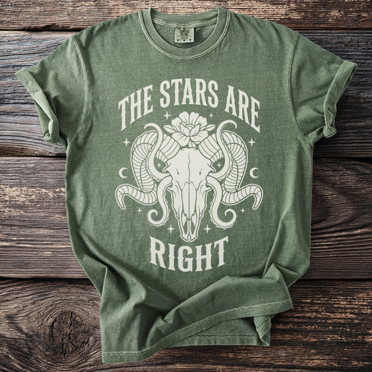 Green t-shirt with white graphic of ram skull, moon, stars, and text "THE STARS ARE RIGHT".