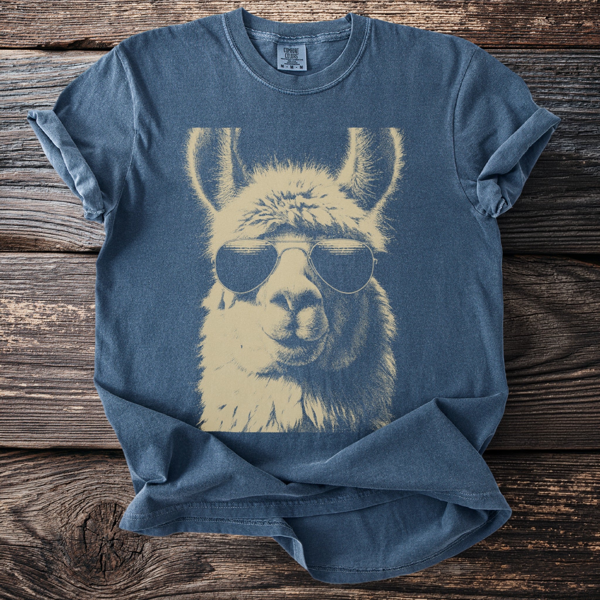 Blue t-shirt with a graphic of a llama wearing aviator sunglasses.
