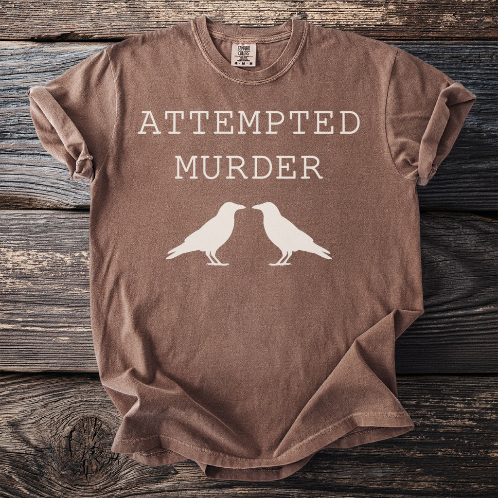 Brown t-shirt with "ATTEMPTED MURDER" and two white ravens.