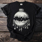 Black t-shirt with a monochrome illustration of a Christmas ornament with mountains and bells.