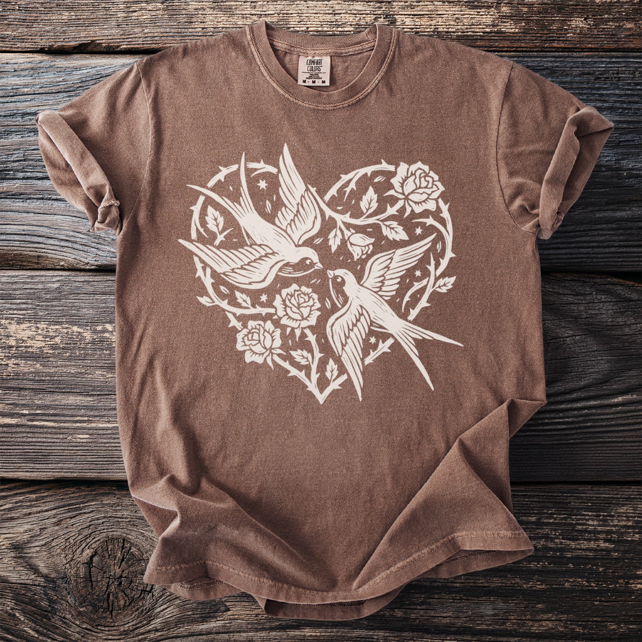 Brown t-shirt with white heart design featuring two swallows and roses.