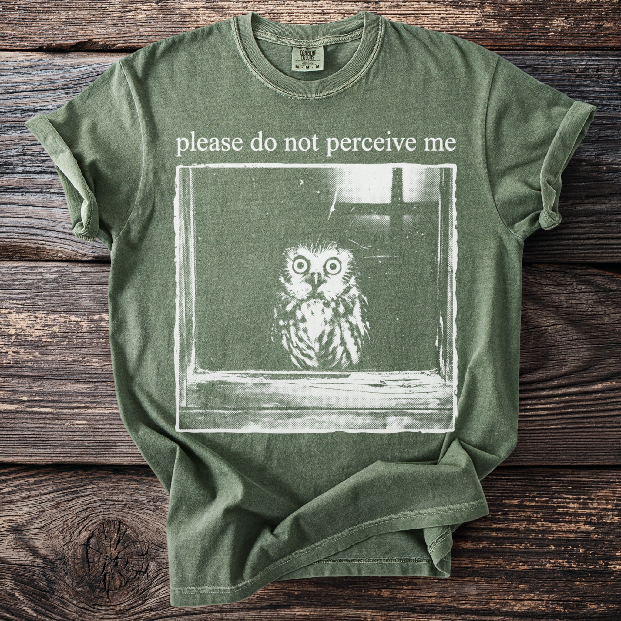 Green t-shirt with a distressed print of an owl and the text "please do not perceive me."