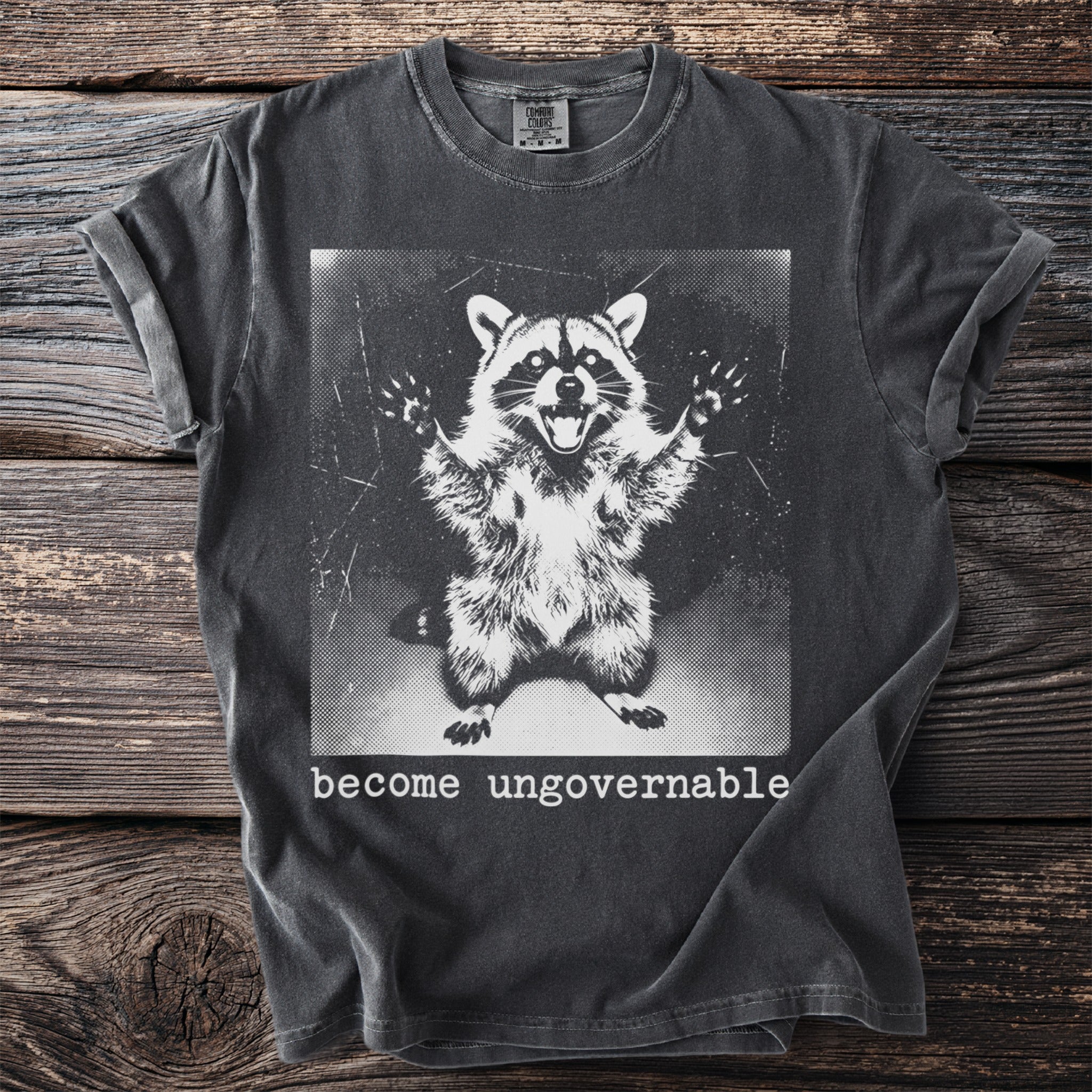 Dark grey t-shirt with graphic of a wide-eyed raccoon and text "become ungovernable".