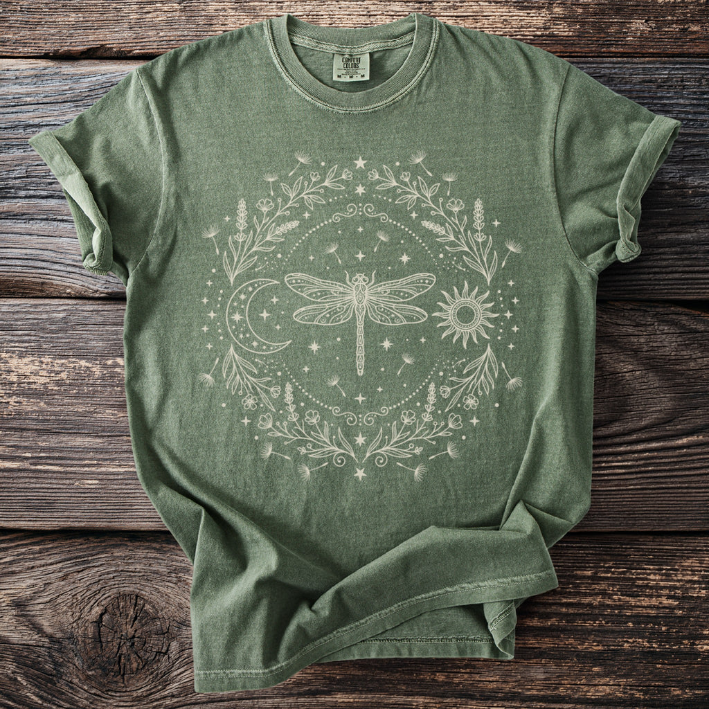Green t-shirt with a circular cream dragonfly, sun, moon, and floral design.