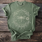 Green t-shirt with a circular cream dragonfly, sun, moon, and floral design.