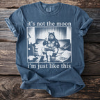 T-shirt with a graphic of a werewolf on a couch, drinking and eating, with text.