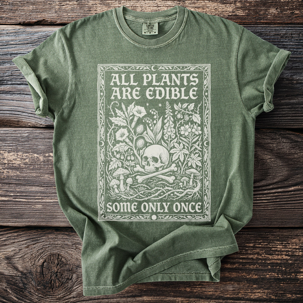 Green t-shirt with white graphic: "ALL PLANTS ARE EDIBLE SOME ONLY ONCE" and skull.