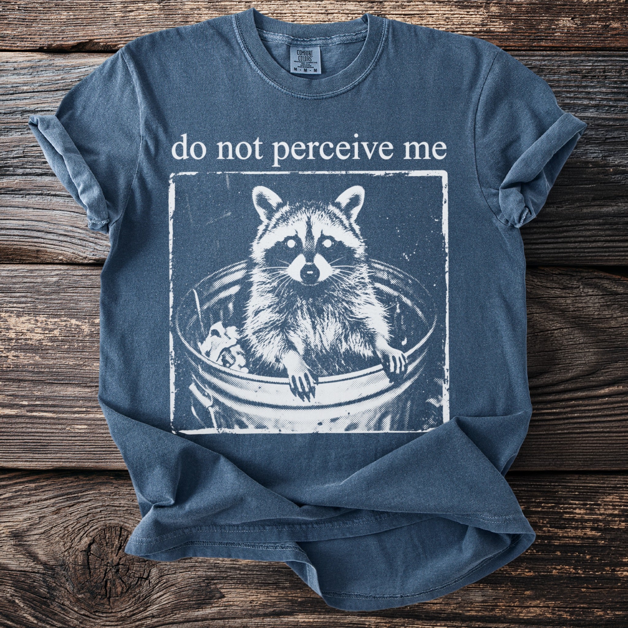 Tee with raccoon in trash bin graphic and text "do not perceive me."